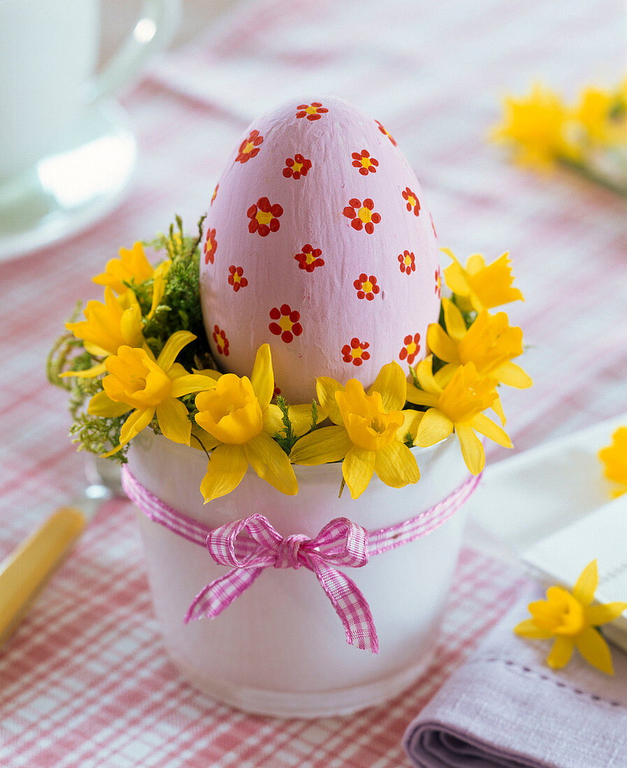 Easter egg with painted flowers in wreath of Narcissus (Daffodil)