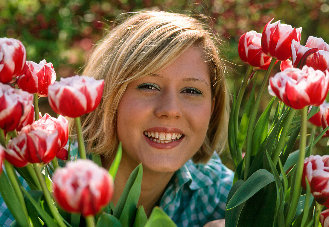 Frau zwischen Tulipa ' Wirosa' (Tulpen)