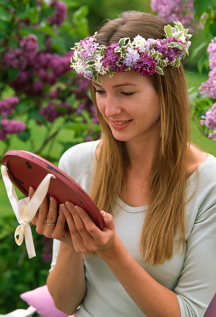 Woman with wreath of Syringa (lilac) and Pittosporum