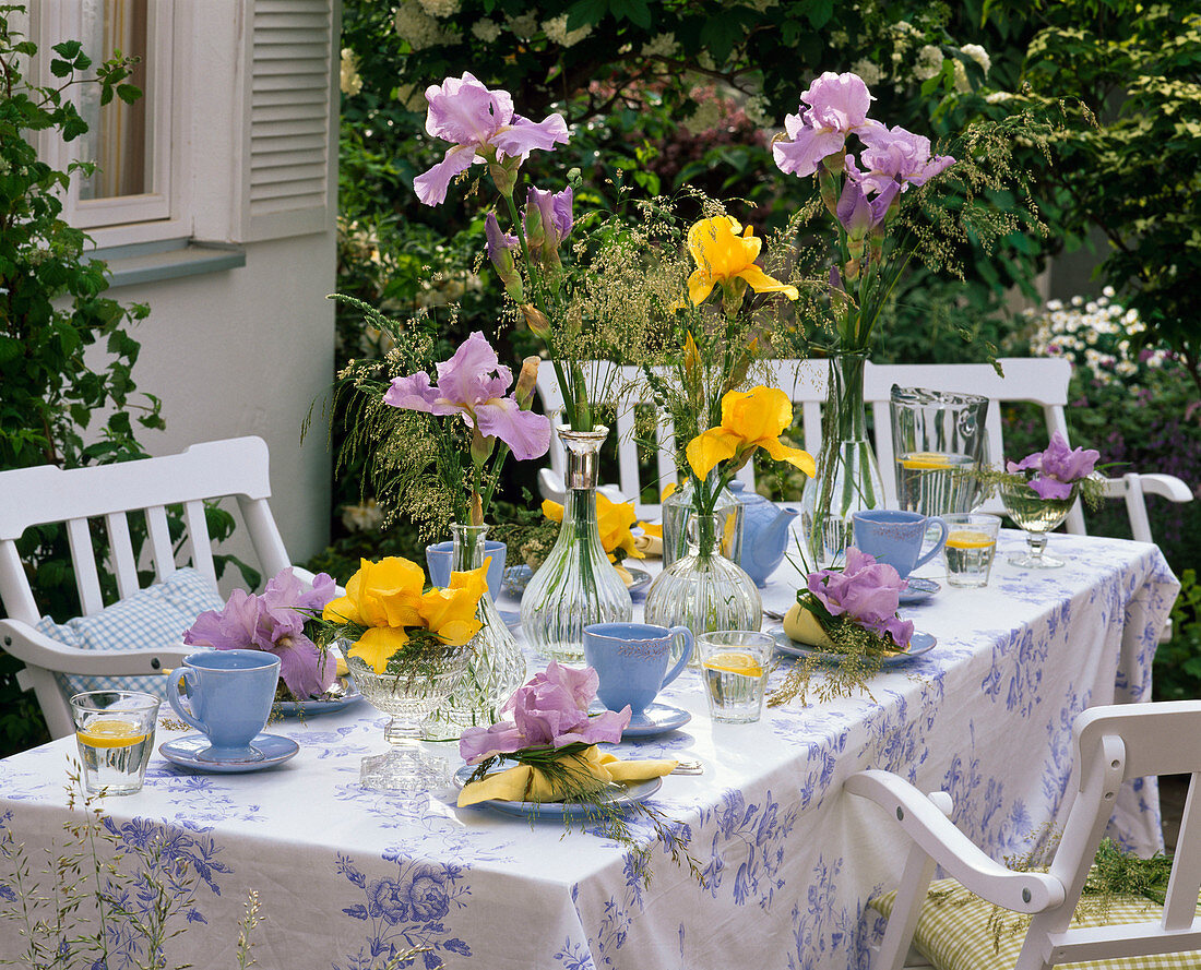 Tischdekoration mit Iris (Schwertlilien) und Gräsern, blaue Gedecke
