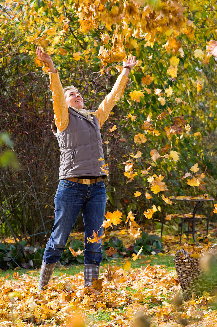 Woman throws leaves in the air