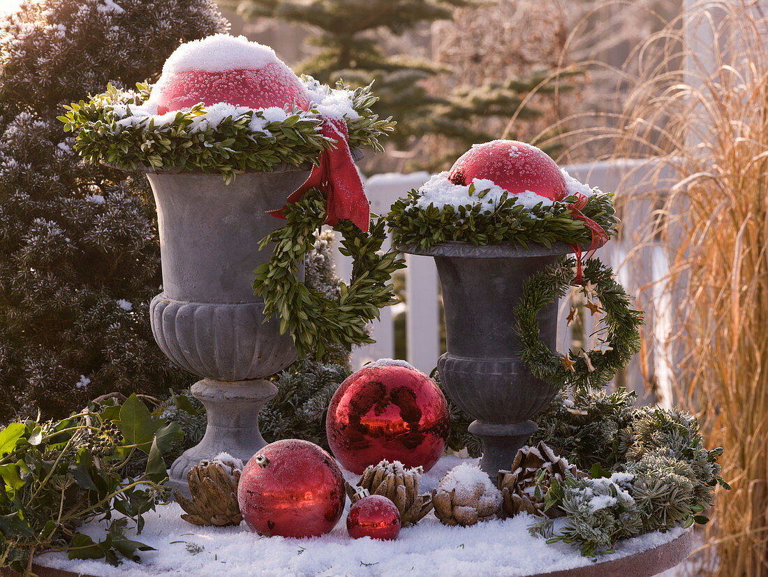 Snow-covered and frosted amphorae with wreaths of Buxus