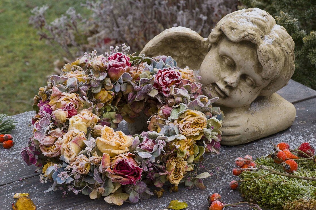 Angel bust with wreath made of pink (rose), hydrangea (hydrangea)