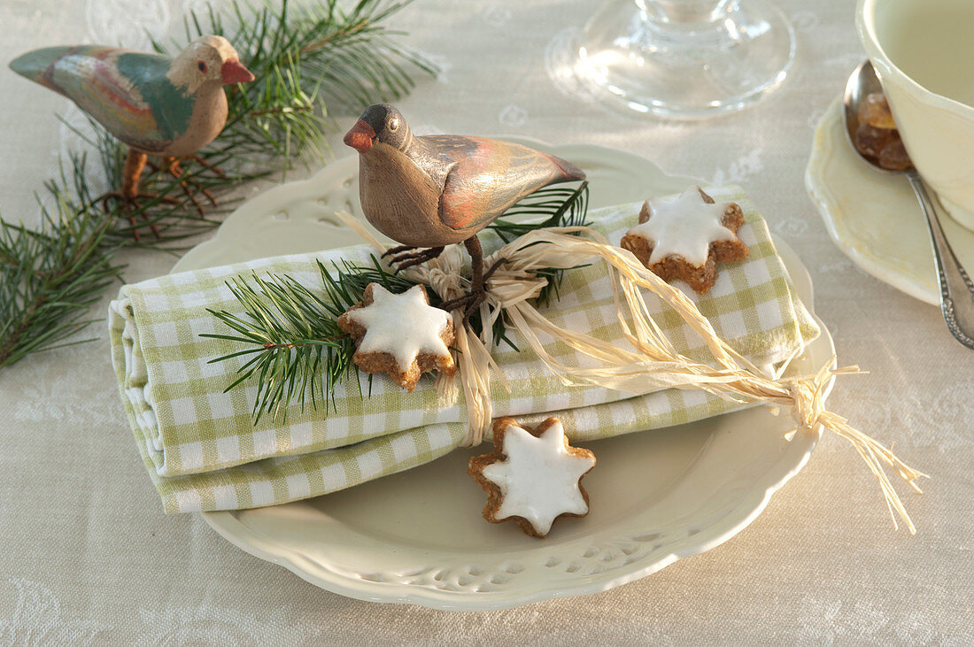 Christmas napkin deco with cinnamon stars, birds