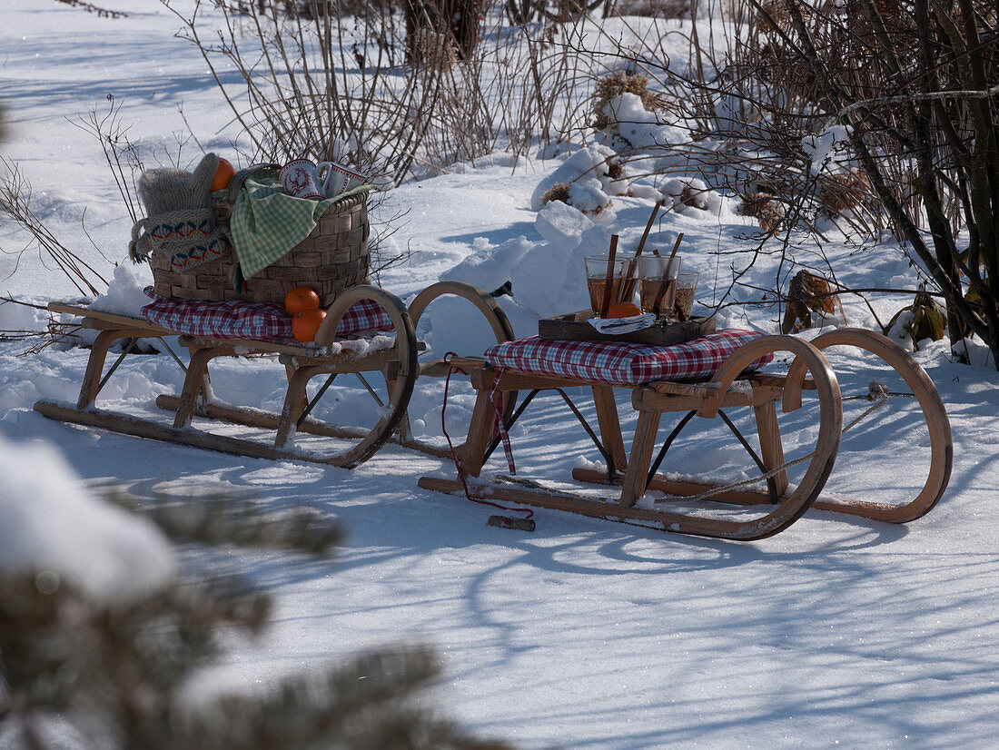 Schlitten im Schnee mit heißem Tee, Citrus (Orangen) und Picknickkorb