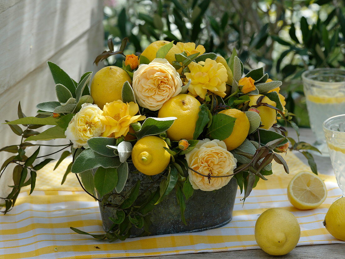 Gelbes Gesteck aus Rosa (gelben Rosen), Citrus limon (Zitronen), Ranken