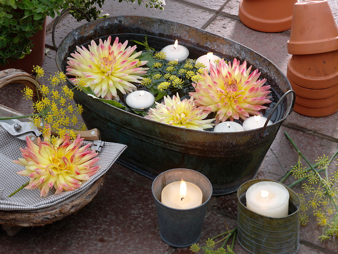 Tin tray with floating dahlia flowers and floating candles