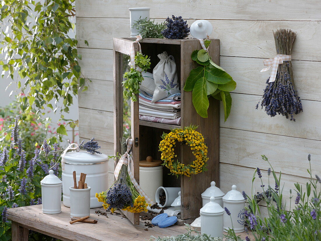 Wooden cupboard decorated with herbs on wooden table