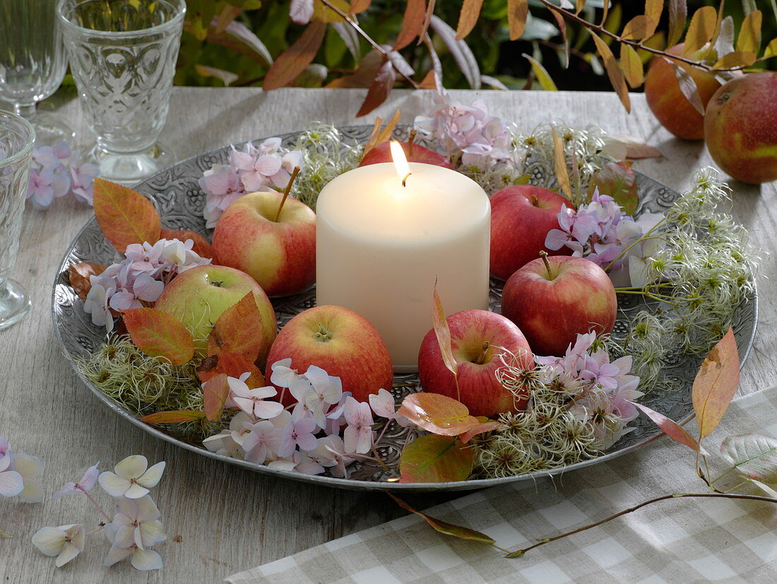 Herbstliche Schale mit Äpfeln und weißer Kerze