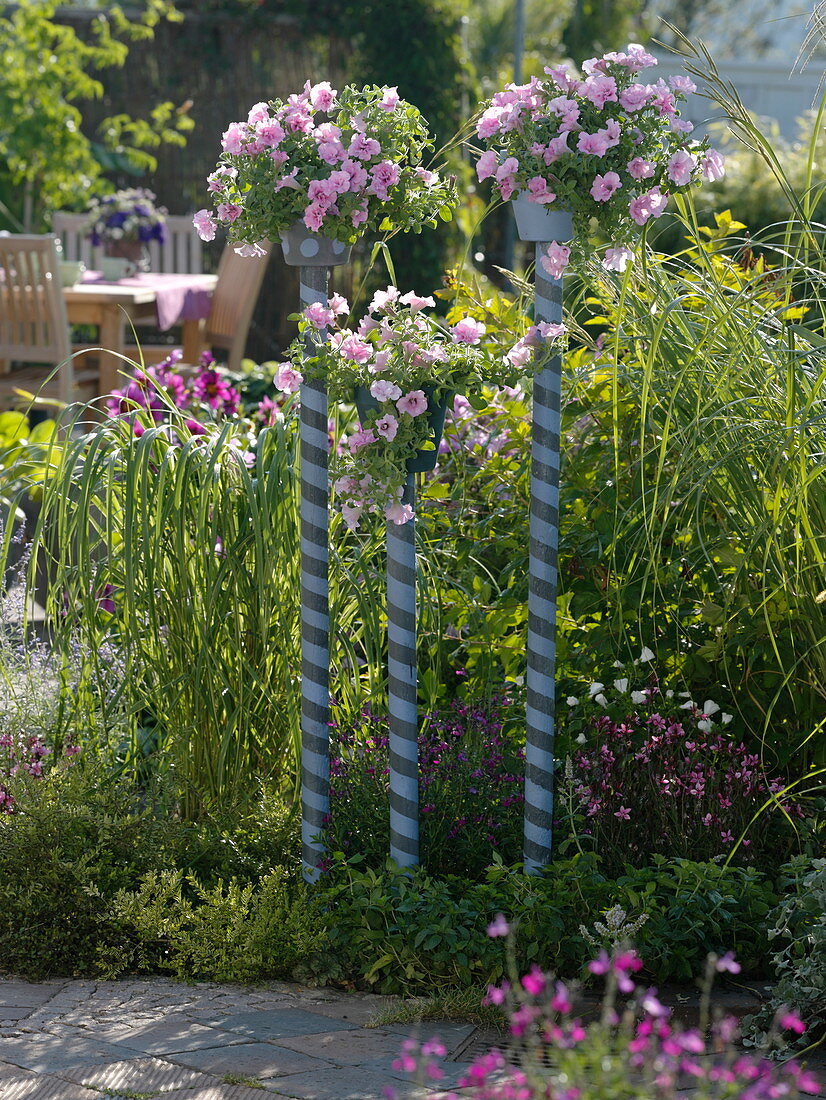 Painted pots on painted rods in the flower bed