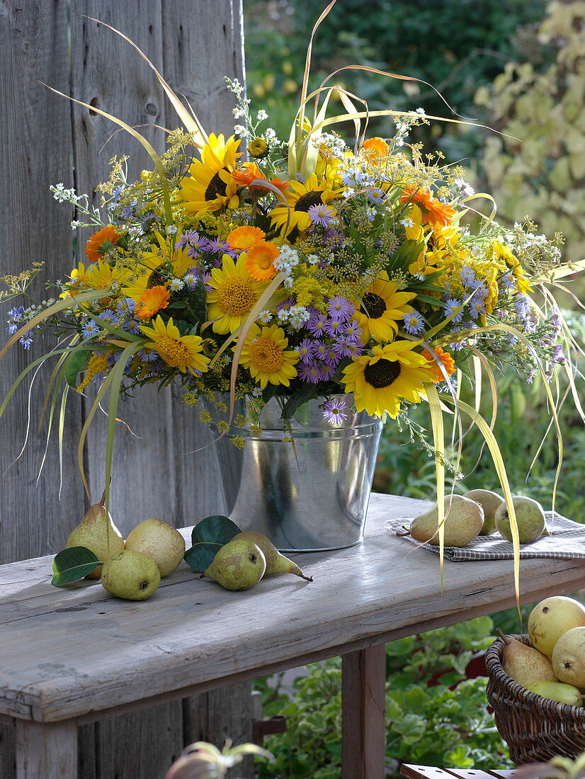 Fragrant sunflowers and asters bouquet in tin tubs