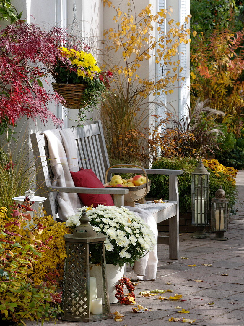Herbstliche Terrasse mit Holzbank und Laternen