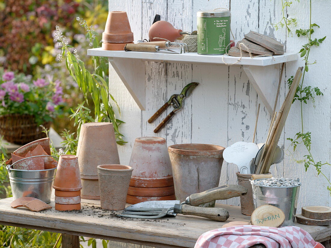 Potting table with clay pots, coasters, small utensils, shards of clay and gravel