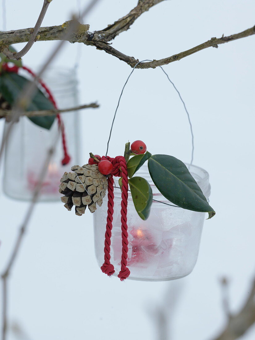 Jam jars hung as lanterns with wire on branch