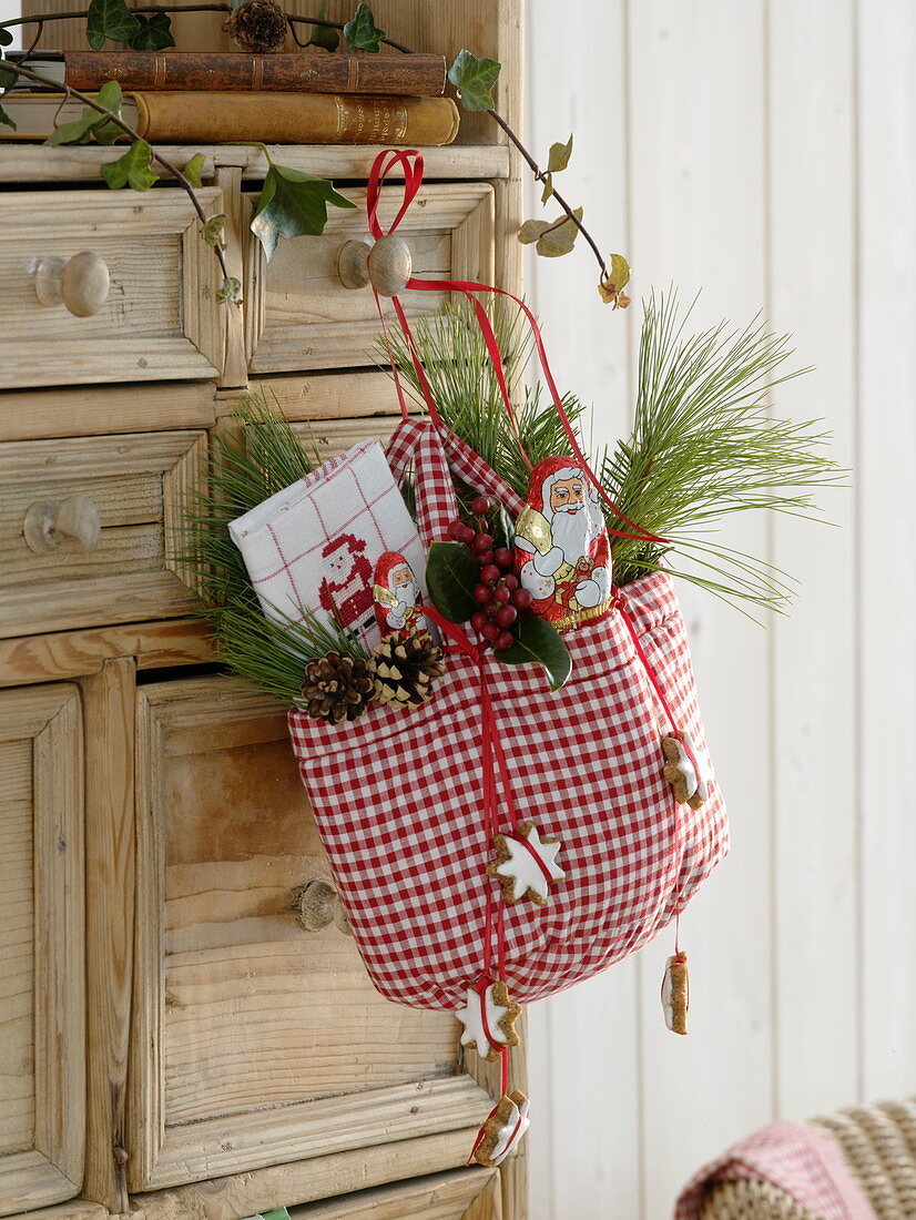 Red and white checkered bag with chocolate St. Nicholas, tea towel, Pinus