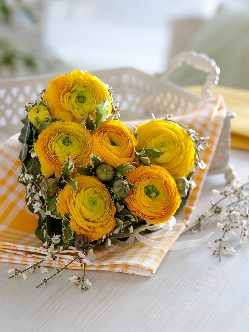 Gestecktes Herz aus Ranunculus (Ranunkeln), Cytisus (Ginster), Hedera