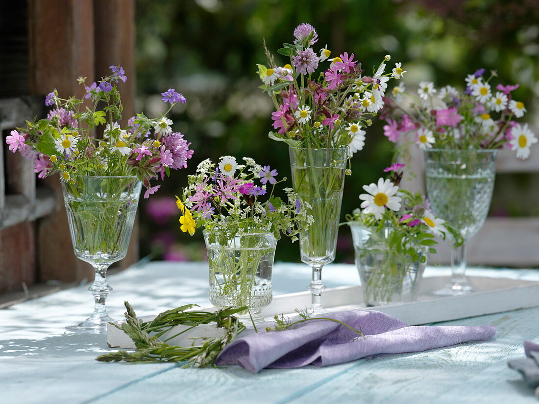 Small meadow flower bouquets in glasses