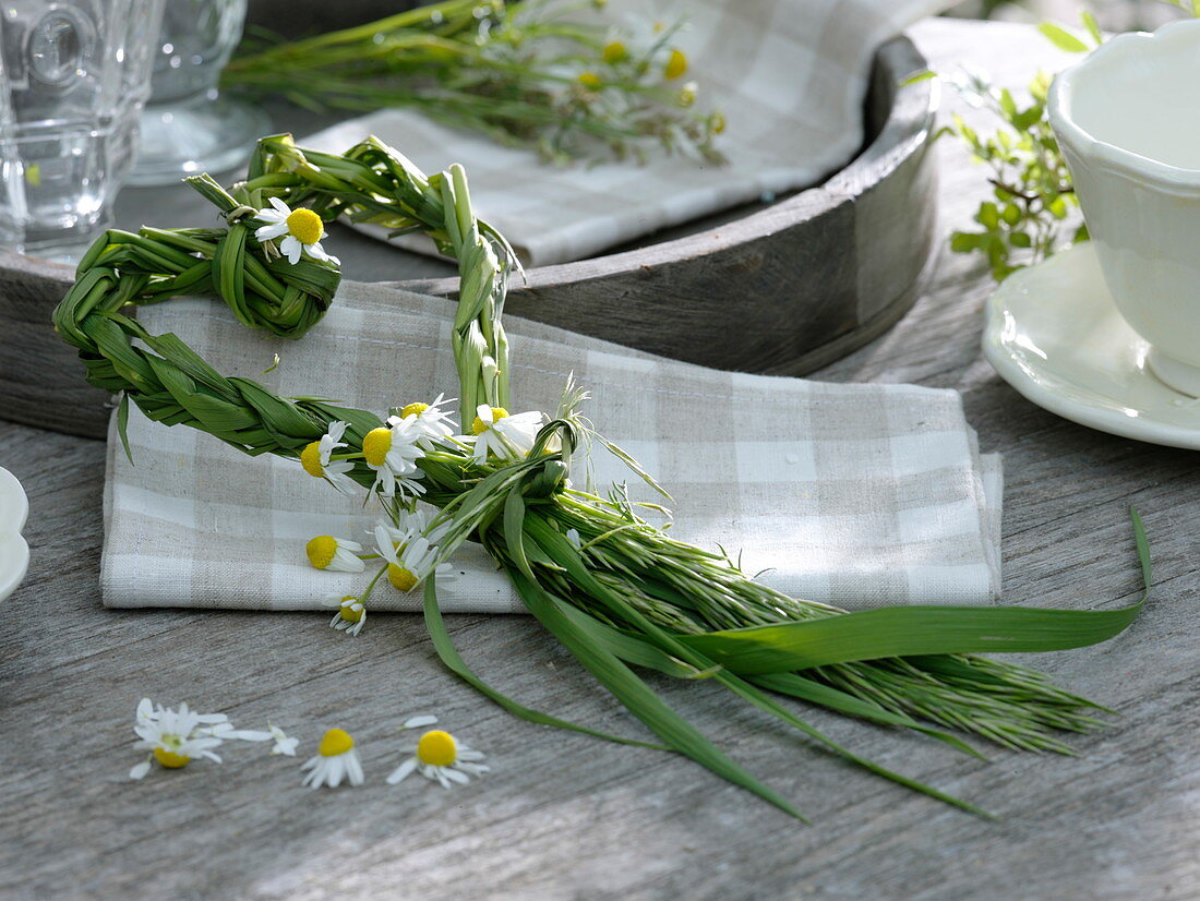 Braided heart of grasses with chamomile flowers