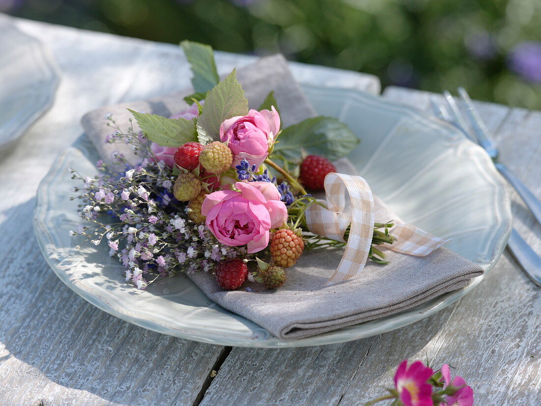 Small bouquet made of raspberries (Rubus), pink (rose), gypsophila