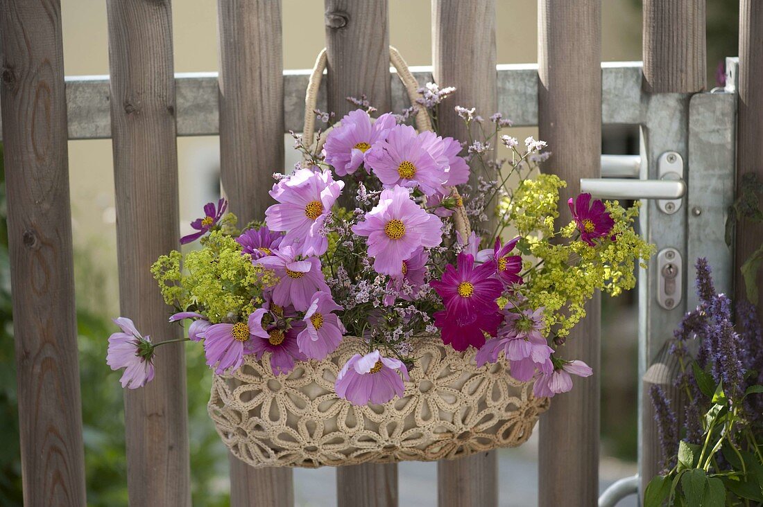 Hanging bag with summer flowers as a welcome to garden gate