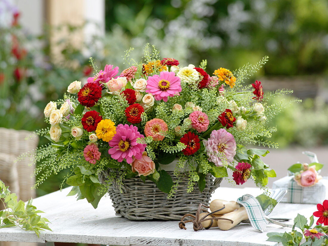 Arrangement of summer flowers and roses in basket
