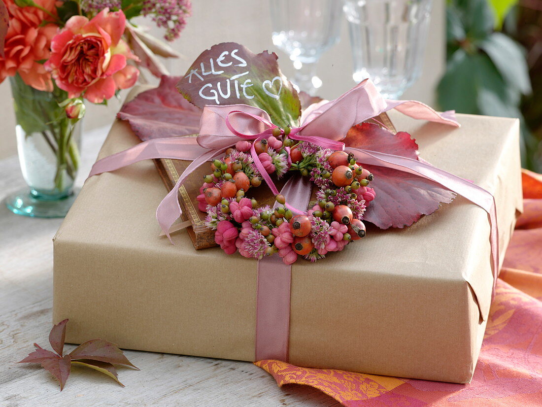 Geschenk herbstlich dekoriert mit Kränzchen aus Rosa (Hagebutten)