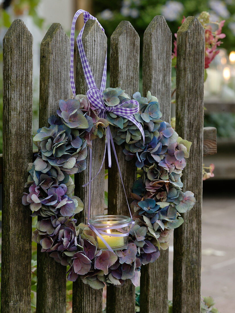 Hydrangea wreath tied to the fence with lantern
