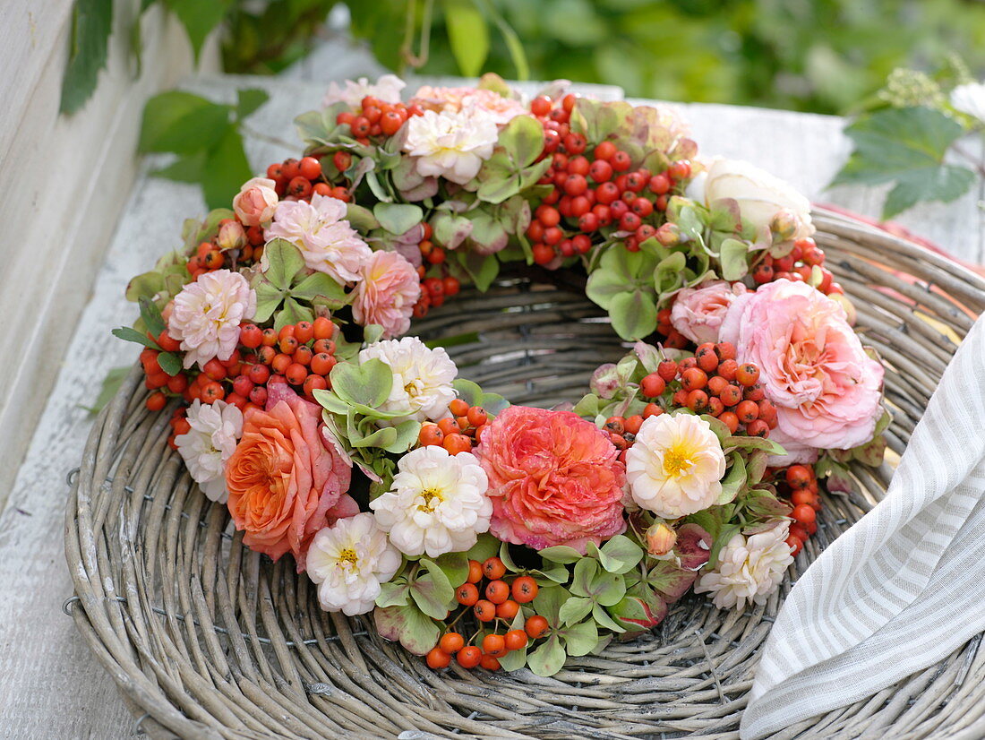 Late summer wreath made of pink (rose), sorbus (rowanberry)