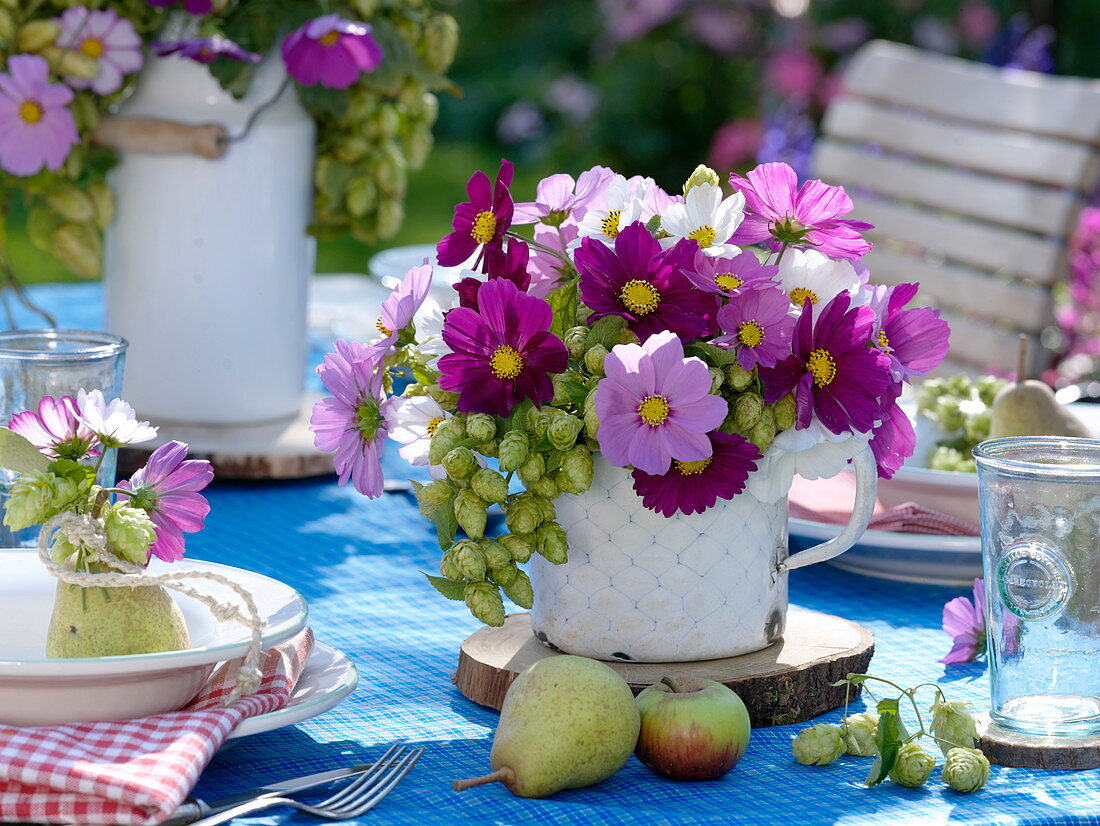 Late summer table decoration with hops and garden cosmos