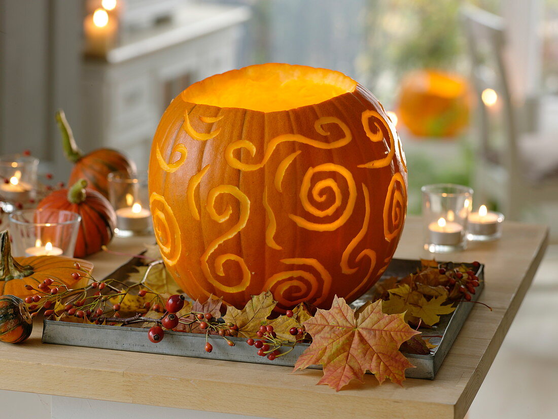 Glowing pumpkin, decoratively carved, as an autumnal table decoration