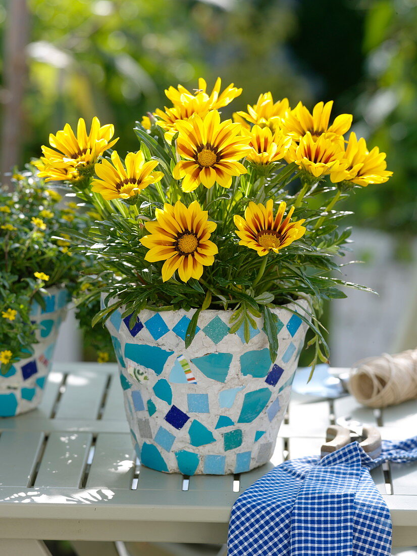 Gluing clay pots with turquoise mosaic