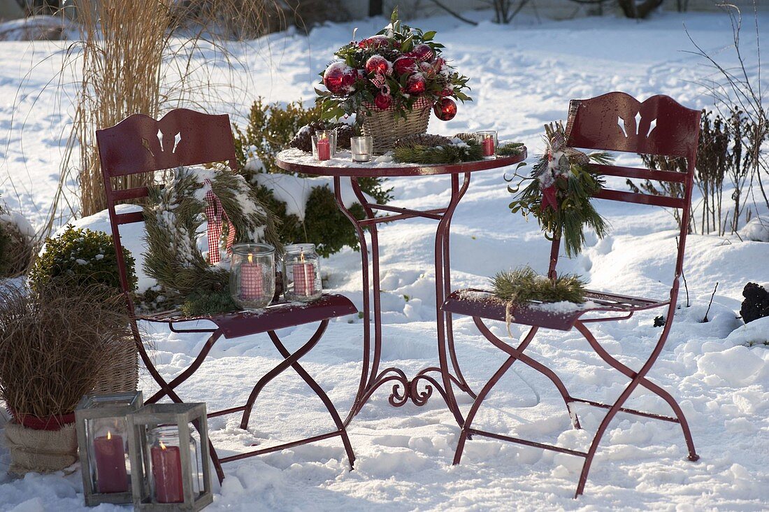Snow-covered terrace festively decorated with a Ilex bouquet