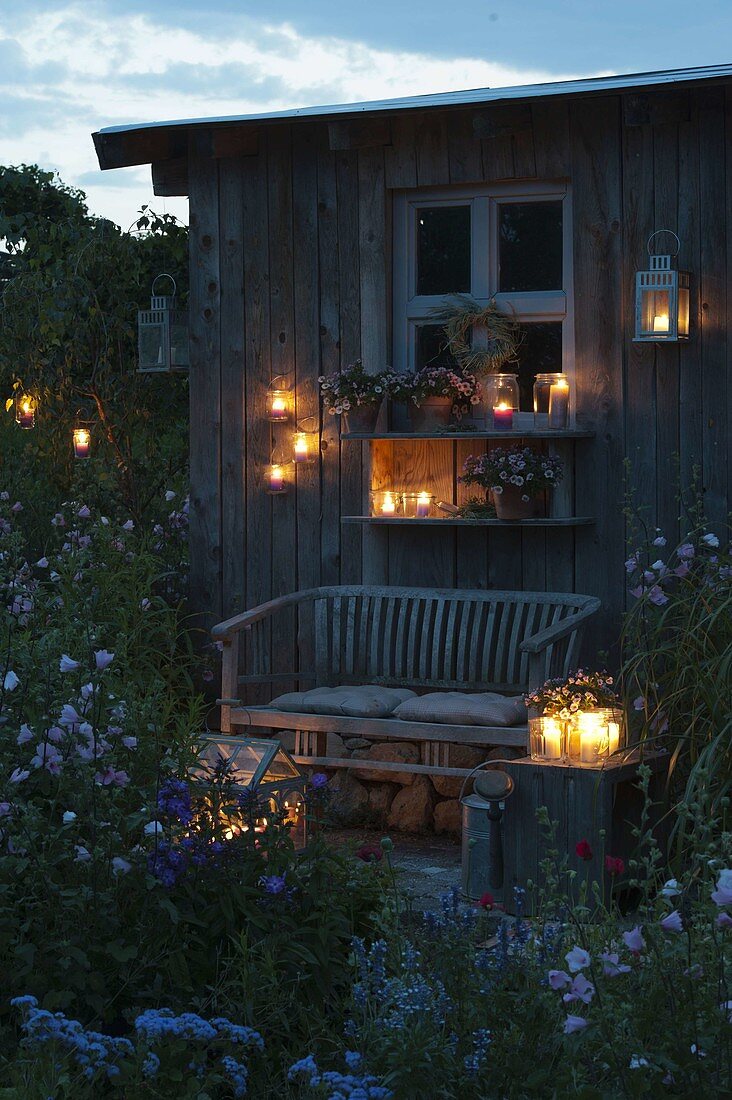Gartenhaus in abendlicher Beleuchtung mit Laternen und Windlichtern