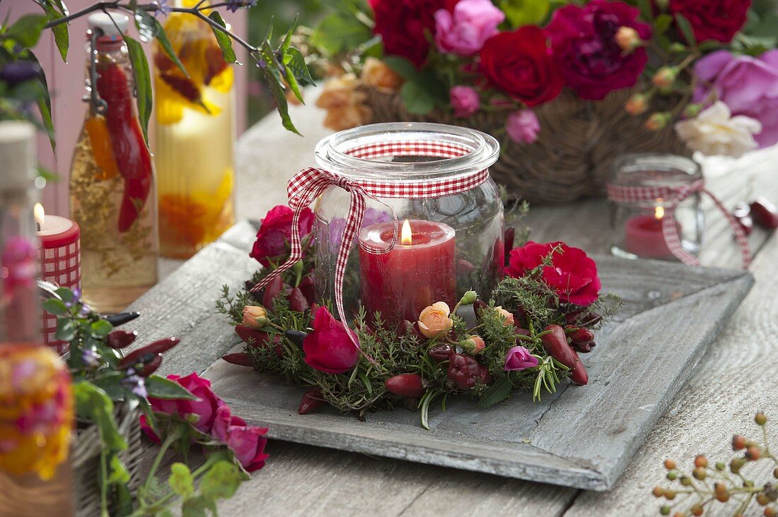 Preserving jar as a lantern with wreath of roses, thyme