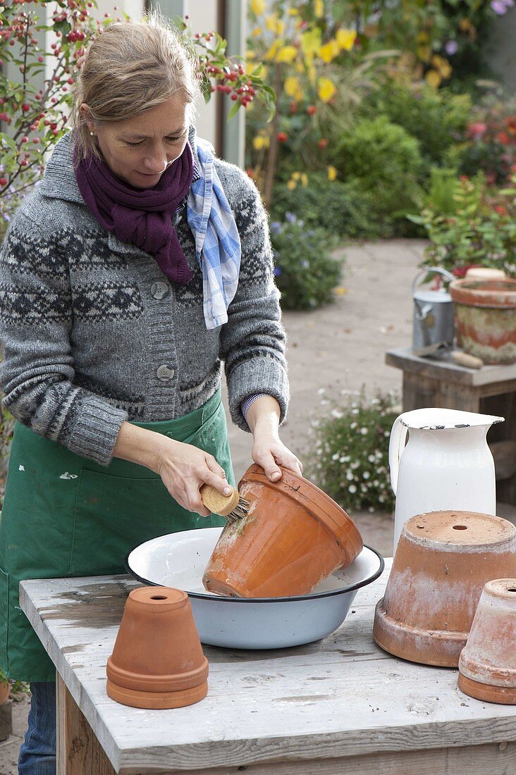 Woman cleans clay pots