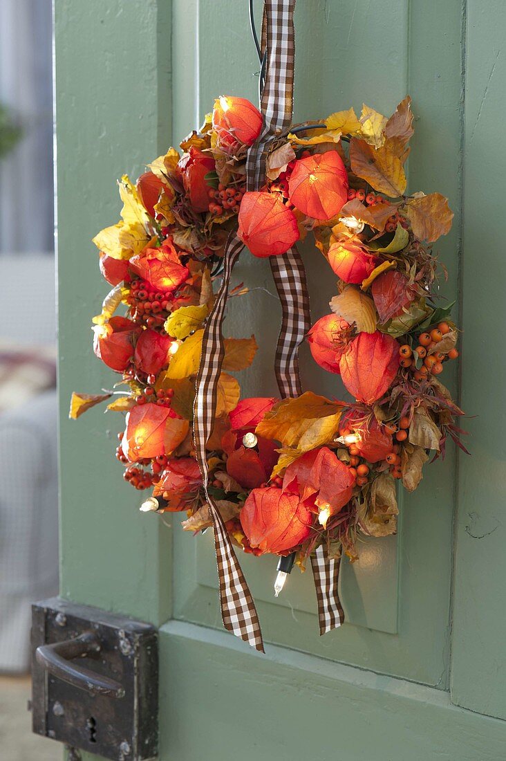 Door wreath made of physalis, pyracantha, leaves