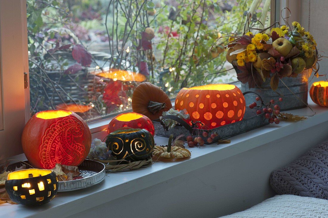 Windowsill decorated with decorative carved pumpkins