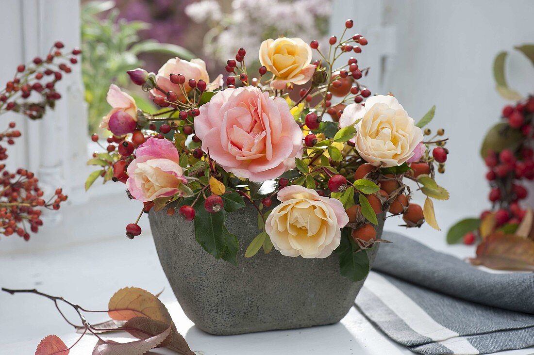 Small pink (rose) and rosehips arrangement at the window