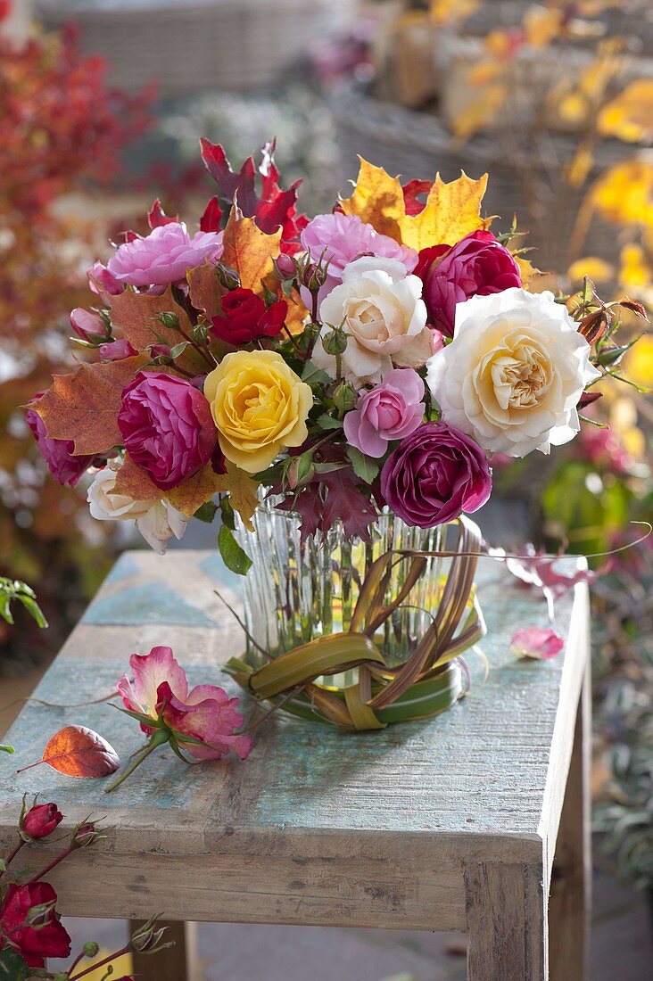 Bouquet of pink (roses) and colourful autumn leaves, bow of leaves