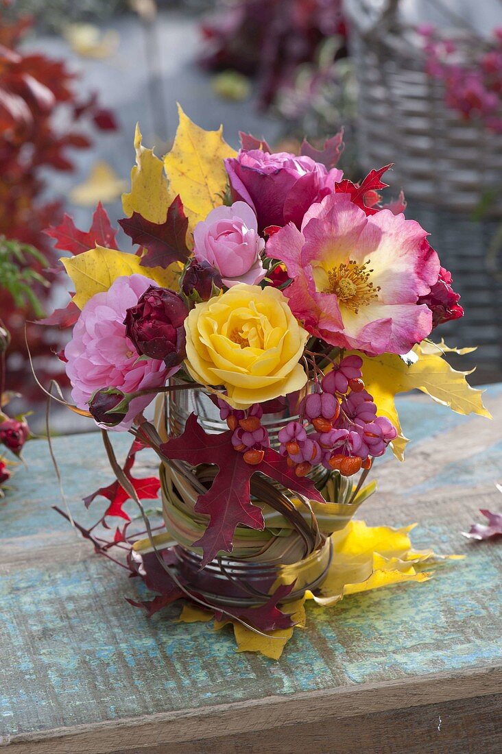 Bouquet of Rosa (roses), Euonymus (peony) and colourful autumn foliage