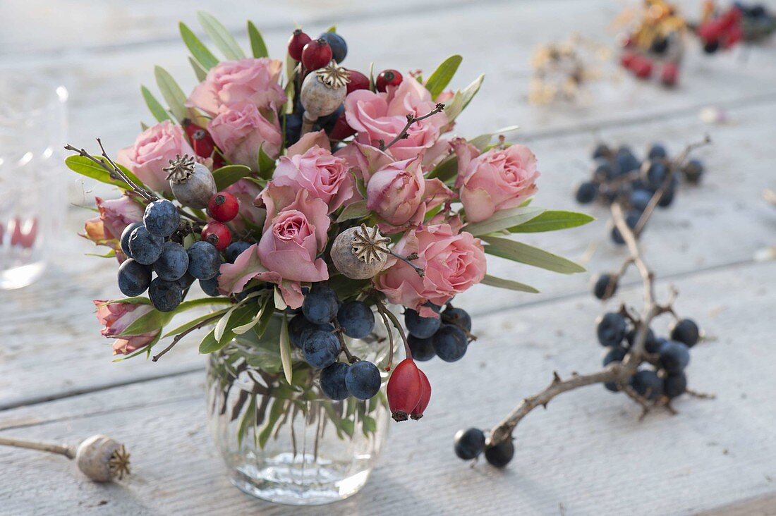 Autumn bouquet with pink (roses, rose hips), sloes (Prunus spinosa)