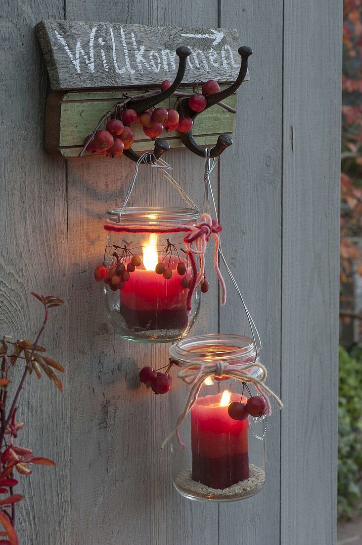 Old preserving jars hung as lanterns on coat hooks