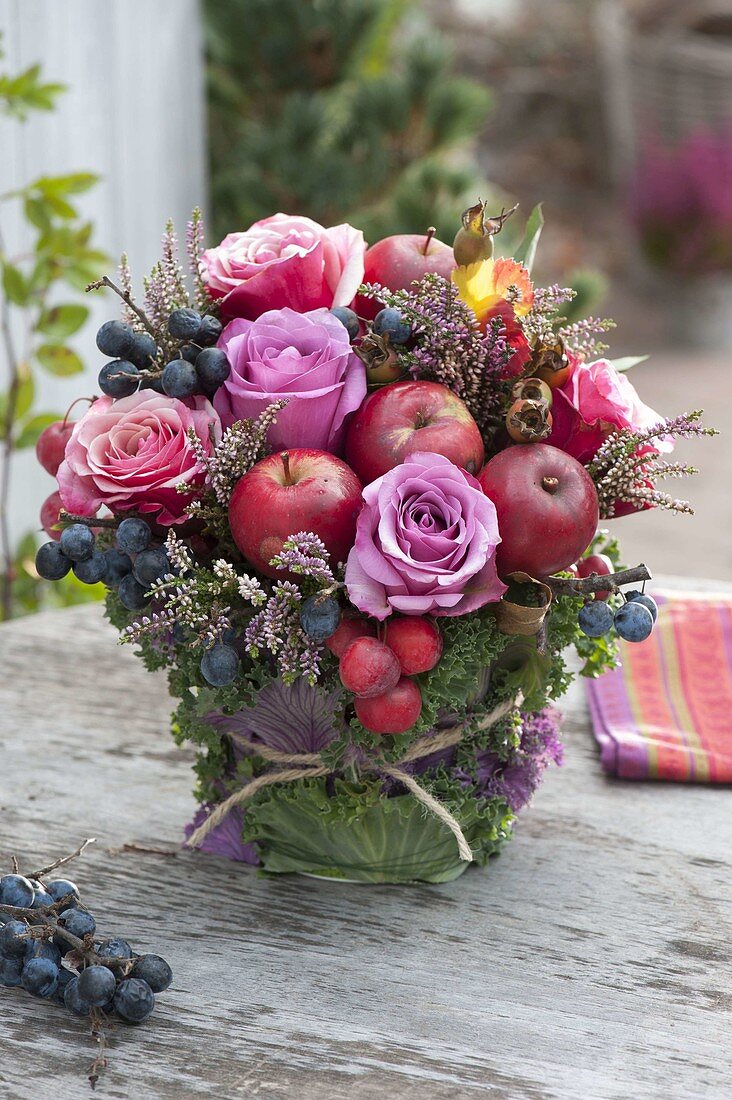 Autumnal bouquet with rose, apples and ornamental apples