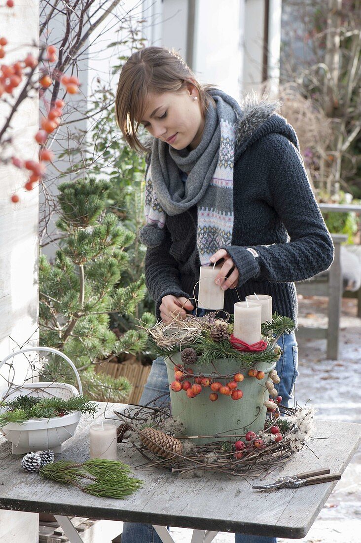 Woman decorates Advent wreath with natural materials