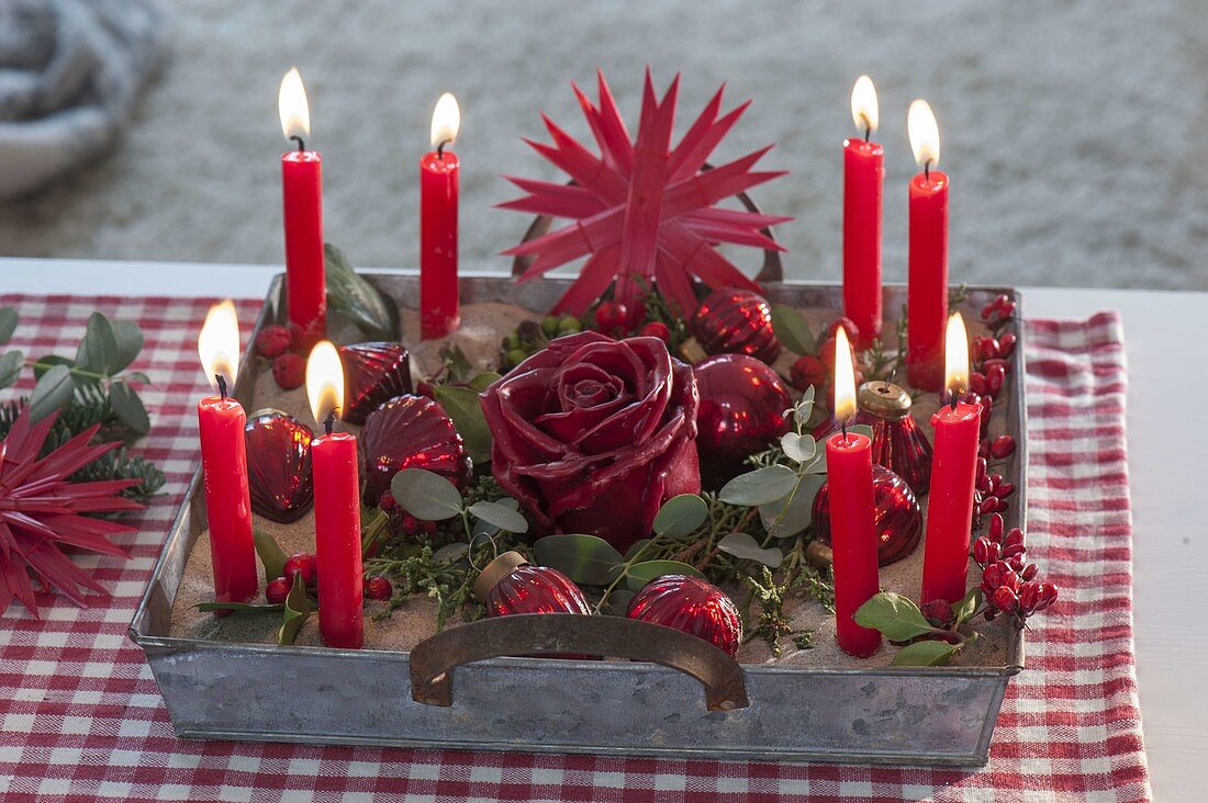 Quick advent wreath with red candles in sand on zinc tray