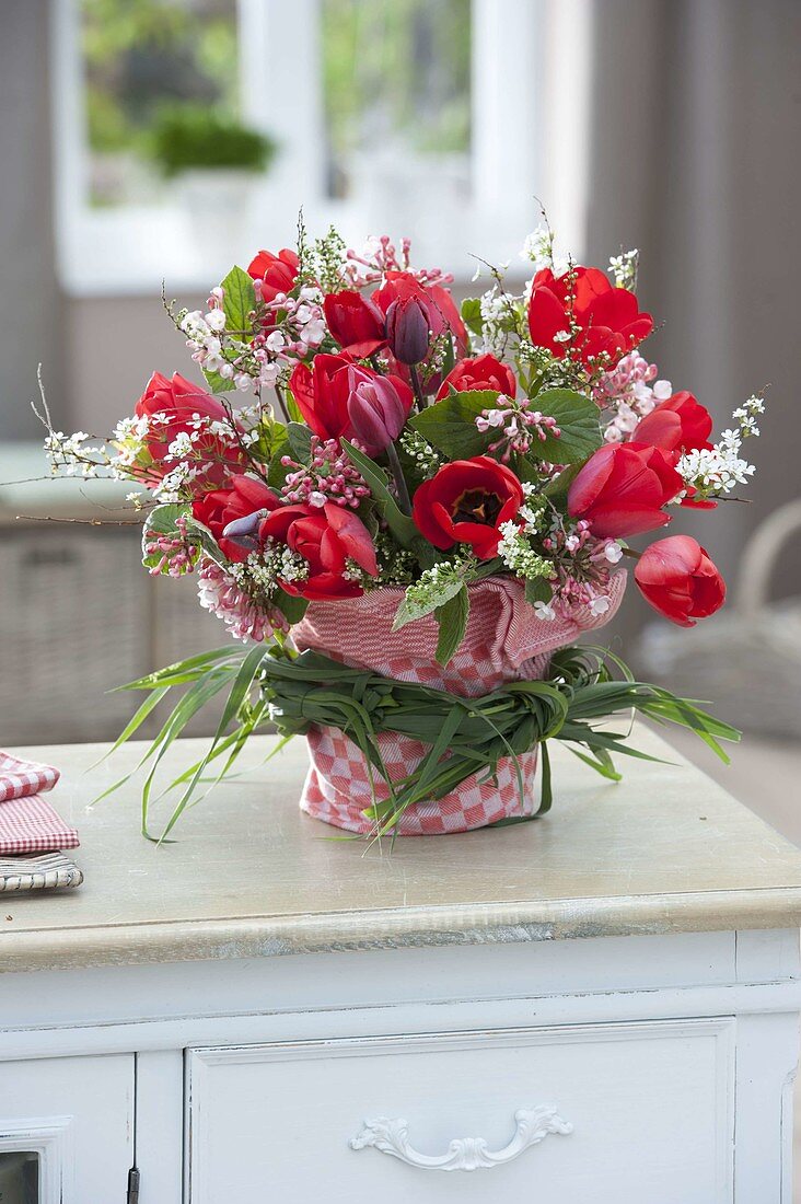 Rot-weisser Strauss mit Tulipa (Tulpen) und Zweigen von Viburnum