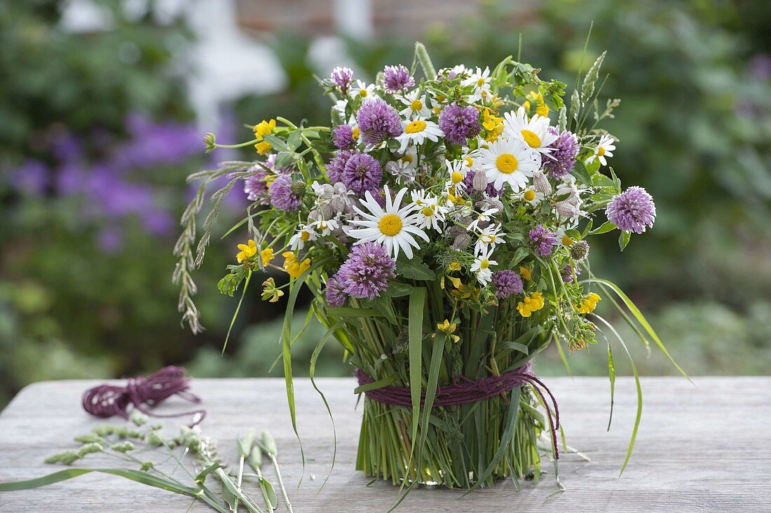 Colourful meadow bouquet in grass-covered vase