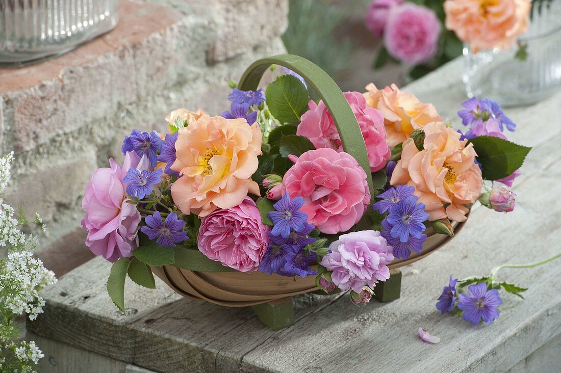 Woodchip basket with different roses and geranium