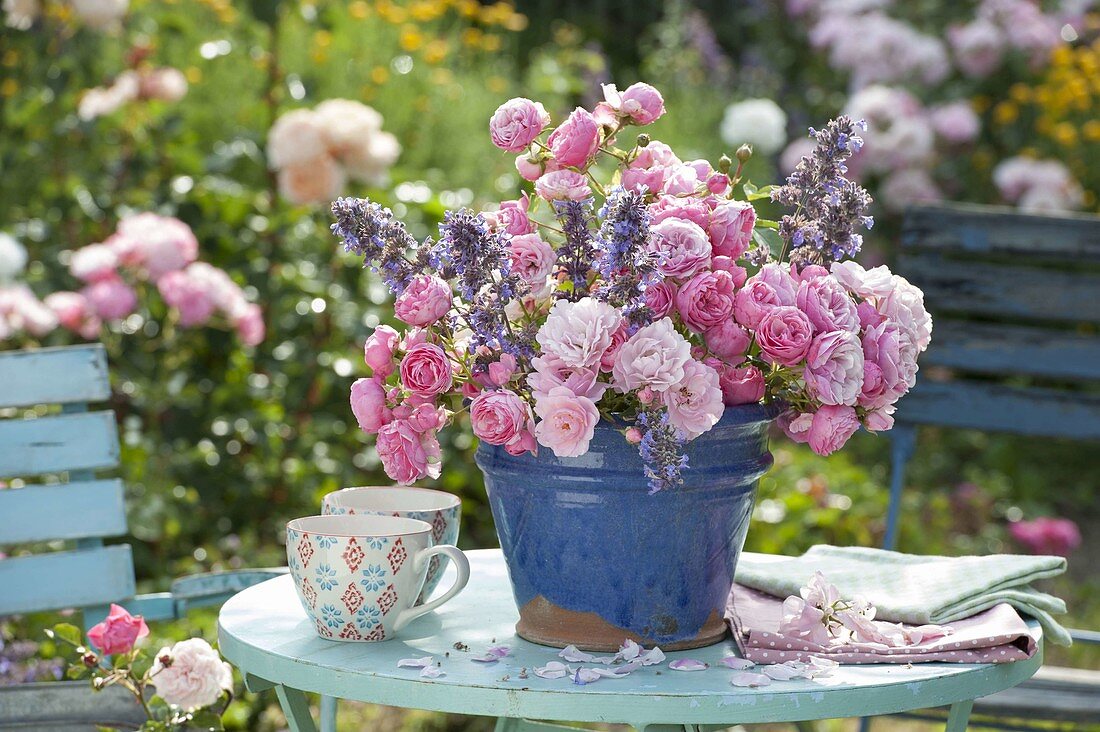 Bouquet of Rosa (roses) and Nepeta (catmint) on table in garden