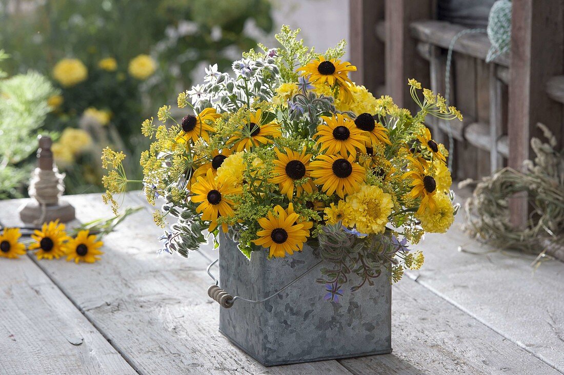 Yellow late summer bouquet in tin container